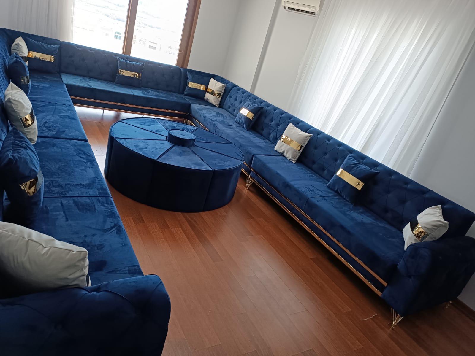 Mavi kumaşlı U biçiminde oturma grubu ve yuvarlak puf